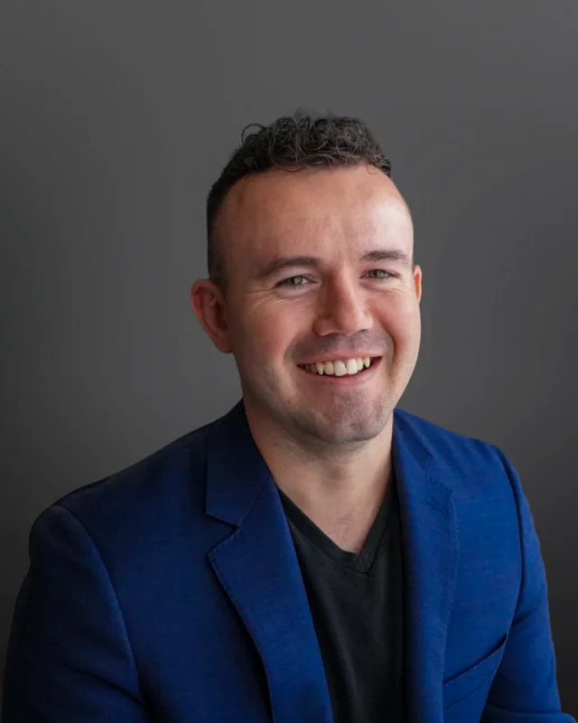 Michael Dienhart smiling in a blue blazer.